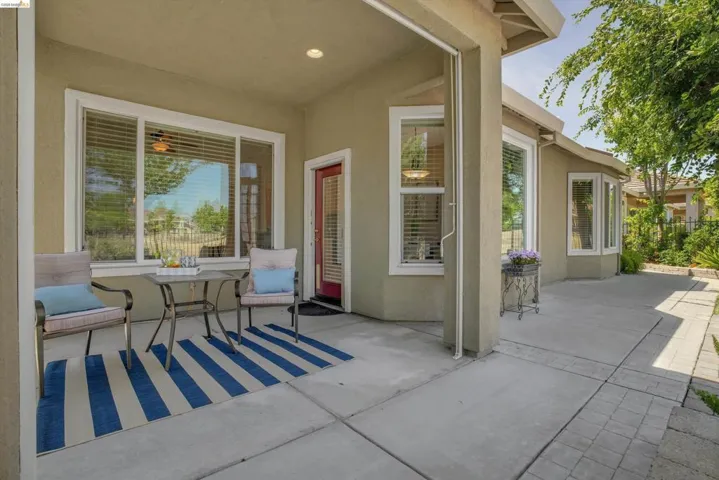 Covered patio featuring a concrete slab and a red entry door