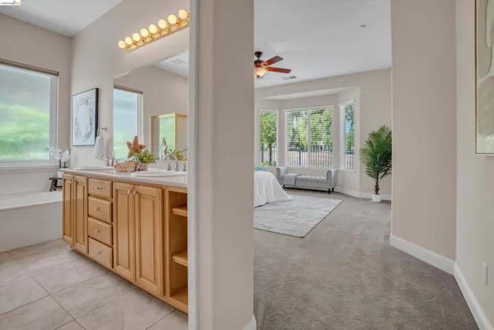 Dual vanity with wood cabinetry, integrated sinks, and polished chrome fixtures