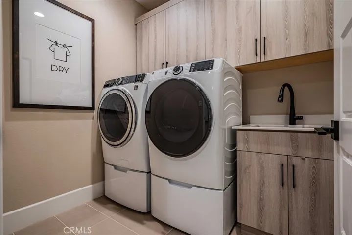 INDOOR LAUNDRY WITH UTILITY SINK AND BASE & OVERHEAD CABINETRY