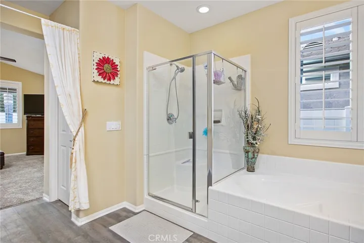 Master ensuite with standing shower, soaker tub, dual sink vanity, and large walk-in closet.