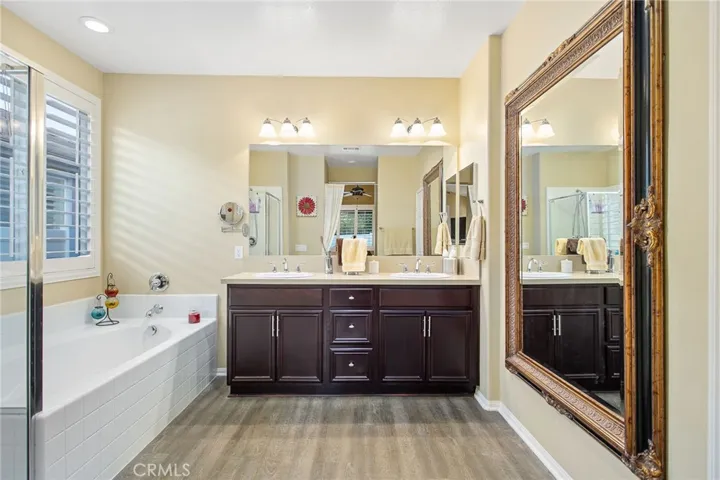 Master ensuite with standing shower, soaker tub, dual sink vanity, and large walk-in closet.