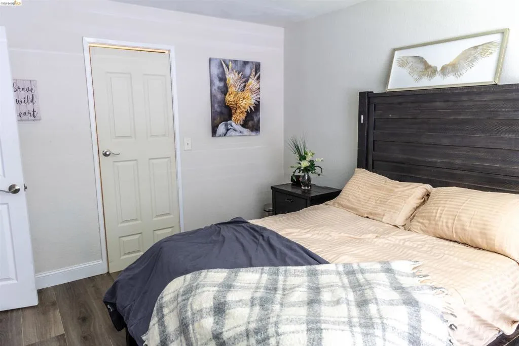 Room featuring wood-finish flooring, white walls, and white trim