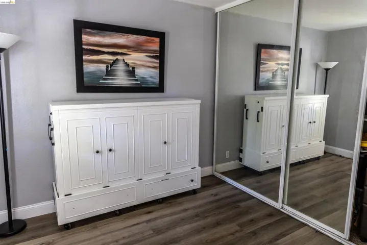Mirrored sliding closet doors complement the wood-finish flooring