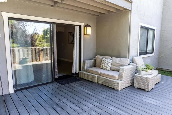 Spacious outdoor deck featuring gray wood-finish decking and a sliding glass door for interior access