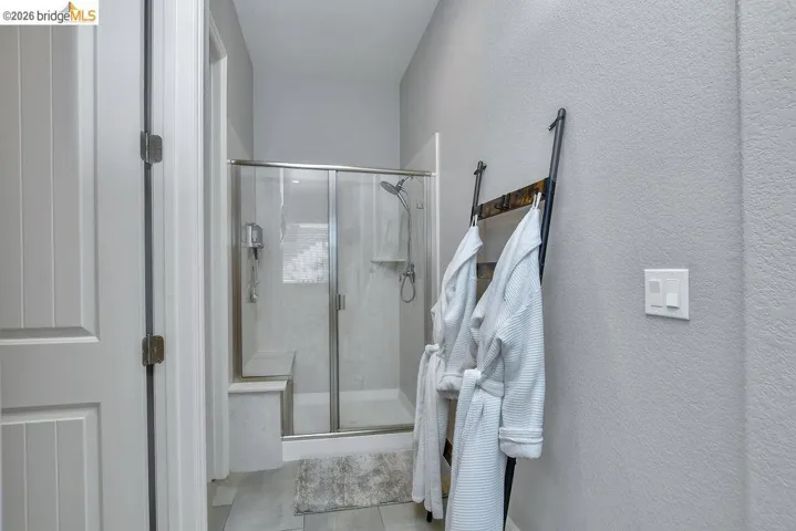 Glass-enclosed shower with a built-in bench, tile surround, and brushed nickel fixtures