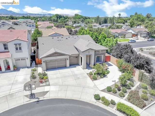 Contemporary residence featuring a two-car garage, concrete driveway, and a tile roof