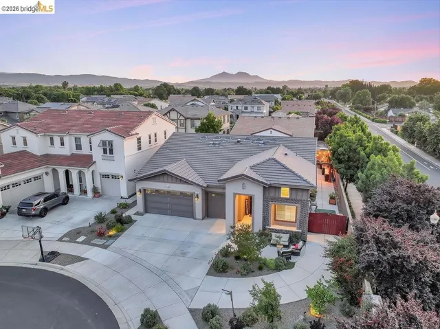 Contemporary residence featuring a grey tile roof and a neutral-toned stucco and stone facade