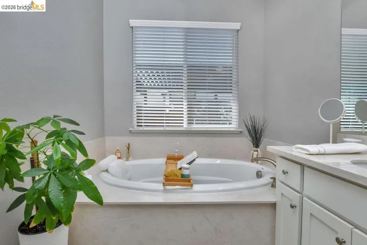 Built-in soaking tub with a surrounding tiled deck and brushed nickel fixtures