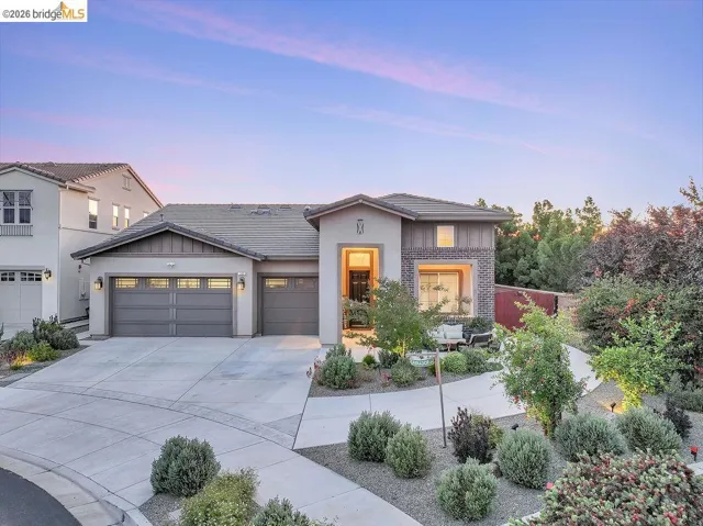 Contemporary residence featuring a three-car garage and a curved concrete driveway