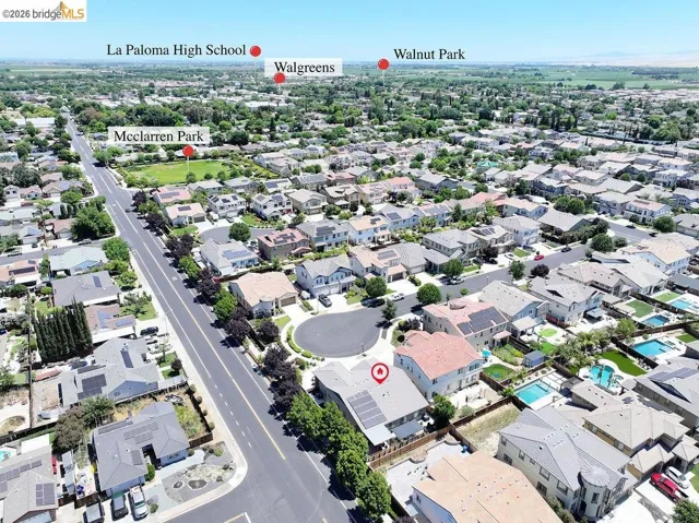 Aerial perspective showcasing a residential neighborhood with numerous homes featuring solar panel installations