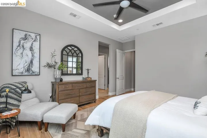 Bedroom featuring a tray ceiling with recessed lighting and a ceiling fan
