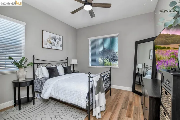 Bedroom featuring wood-finish flooring, a ceiling fan, and neutral painted walls