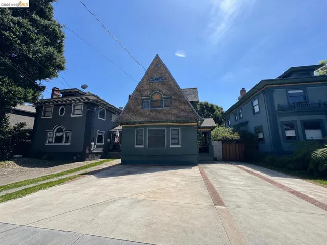 Unique architectural facade featuring a prominent peak roof with shingle siding