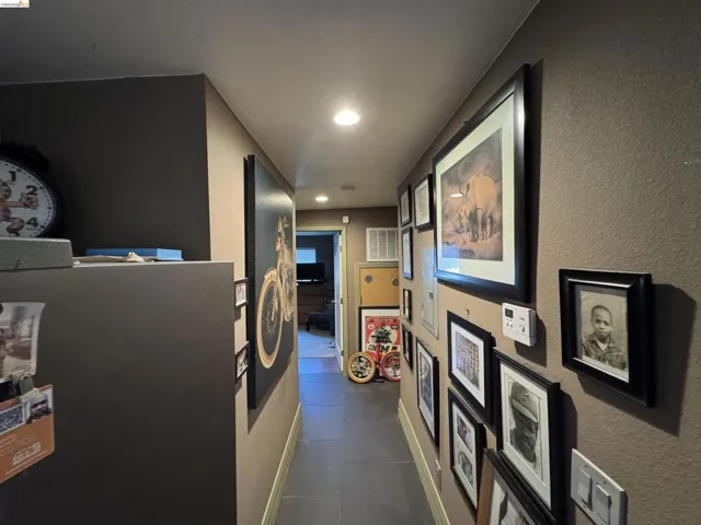Hallway featuring recessed lighting and durable tile flooring