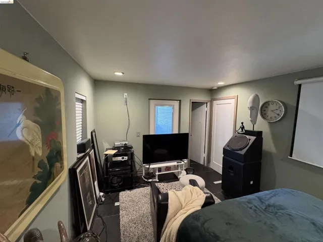 Recessed ceiling lighting illuminates a room with light green walls and dark tile flooring