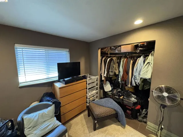 Recessed lighting illuminates a built-in closet with ample storage