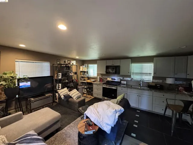 Open-concept living space featuring recessed lighting, multiple windows with blinds, and durable flooring