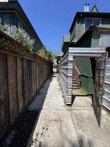 Concrete pathway alongside a wood plank fence
