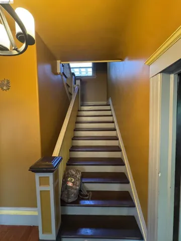 Hardwood staircase featuring painted risers and dark-stained treads