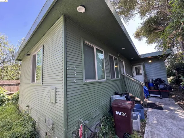 Horizontal siding exterior with multiple windows, recessed lighting, and a concrete pathway