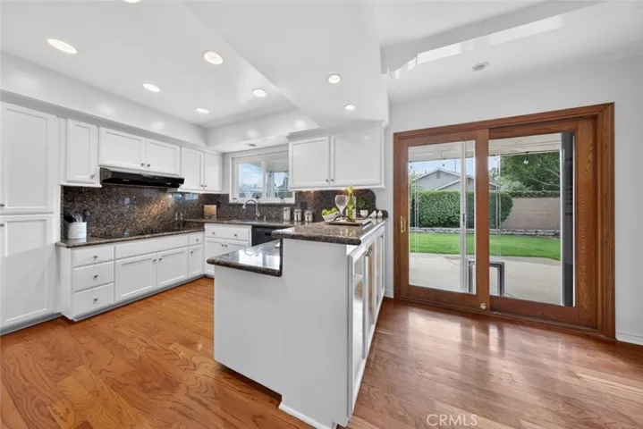 Enjoy the kitchen and views into the lush landscaping backyard with grass and patios.