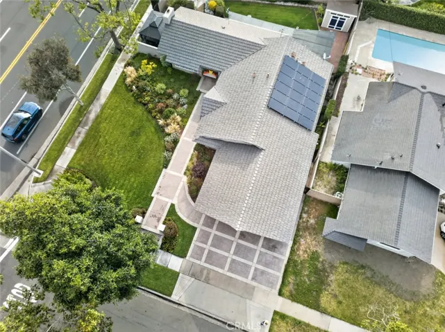 Drone shot of large corner lot, solar panels, and lush green yards.