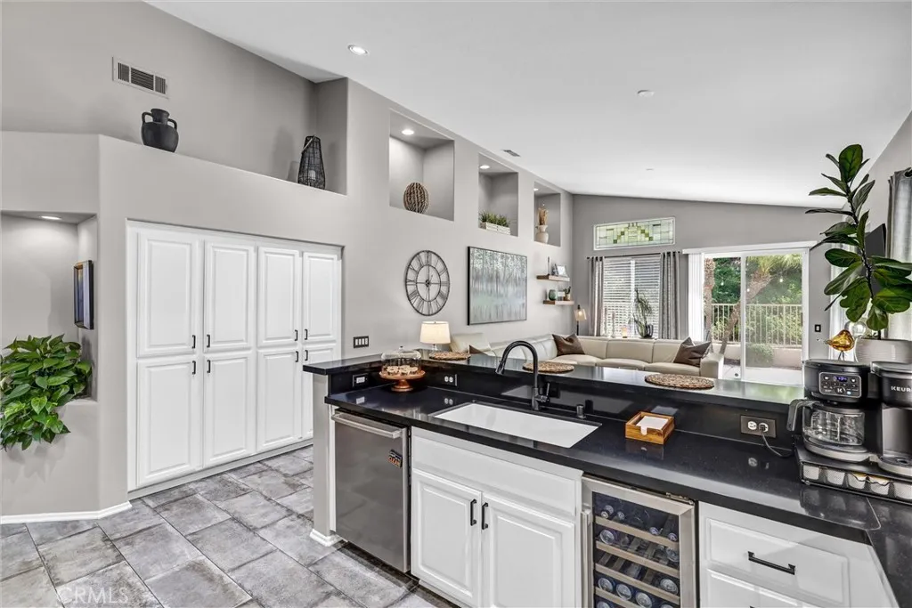 Kitchen open to Fmily Room offers tile flooring and lots of storage area, built-in wine refrigerator and stainless steel appliances