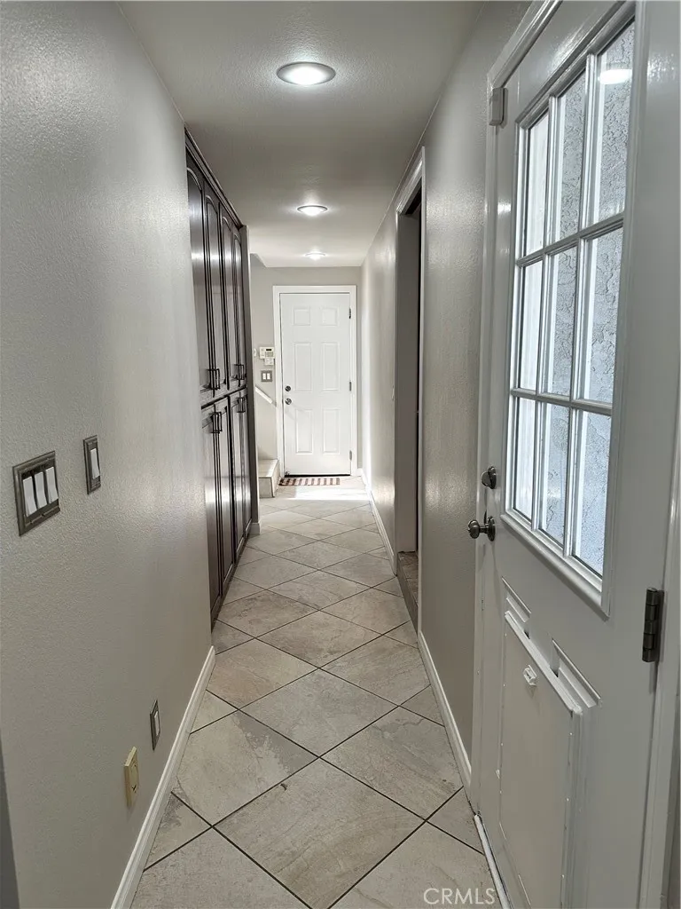 East side hall with access to backyard, garage, kitchen, pantry, bonus room, one full bath and 2 bedrooms.