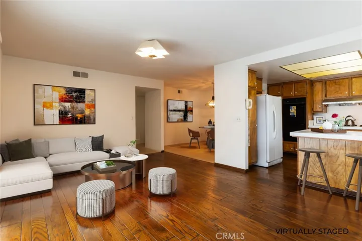 VIRTUALLY STAGED family room looking towards the dining room and hallway to the bedrooms
