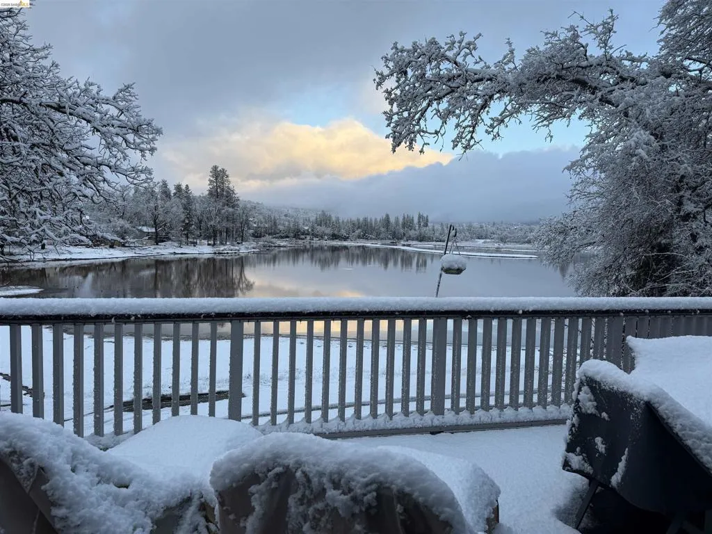 Expansive deck featuring a white railing system, offering direct water frontage