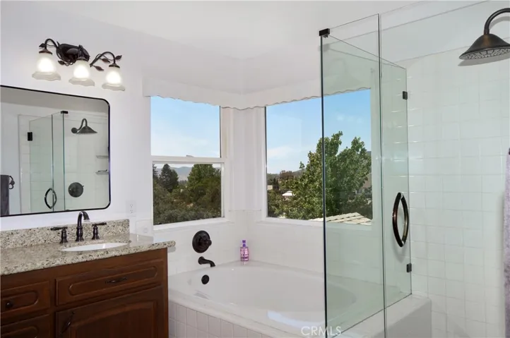 The Main Suite's Bath Boasts Incredible Views, Separate Tub and Shower, Dual Sinks, a Private Toilet Room, and a Walk-in Closet. It has Been Updated with an Extended Shower Enclosure, Granite Countertops, Modern Fixtures and Lighting.