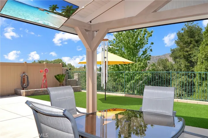 Covered Patio Retreat with the Privacy Shades Open. The TV, Heater, and Lights are Included to Combine the Best of Indoor/Outdoor Living while Enjoying Your Amazing Backyard (screen simulated)