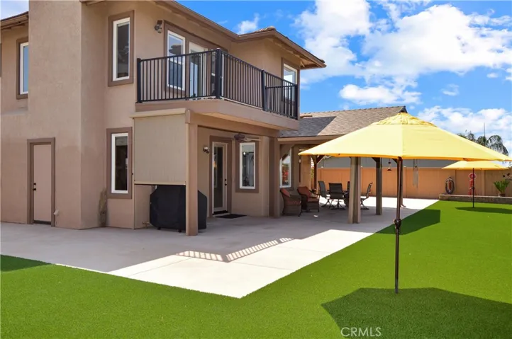 Welcome to the Backyard! Here You'll Love the Covered Patio Retreat which has Remote-Controlled Floor-to-Ceiling Privacy Shades (You Can See out, but Others Can't See in) with a TV, Heater, and Lights Included; TWO Buildings for Hobbies/Crafts/Projects; Abundant Concrete Patio Space; High-End Artificial Lawn; and Delicious Navel Oranges with Mature Oaks and Other Trees Lining the Property Below.