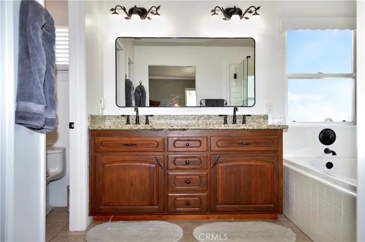 The Main Suite's Bath Boasts Incredible Views, Separate Tub and Shower, Dual Sinks, a Private Toilet Room, and a Walk-in Closet. It has Been Updated with an Extended Shower Enclosure, Granite Countertops, Modern Fixtures and Lighting.