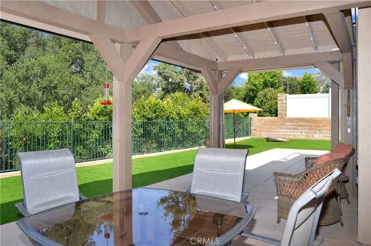 Covered Patio Retreat with the Privacy Shades Open. The TV, Heater, and Lights are Included to Combine the Best of Indoor/Outdoor Living while Enjoying Your Amazing Backyard