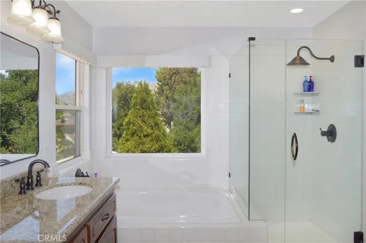 The Main Suite's Bath Boasts Incredible Views, Separate Tub and Shower, Dual Sinks, a Private Toilet Room, and a Walk-in Closet. It has Been Updated with an Extended Shower Enclosure, Granite Countertops, Modern Fixtures and Lighting.