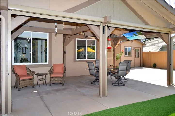 Covered Patio Retreat with the Privacy Shades Open. The TV, Heater, and Lights are Included to Combine the Best of Indoor/Outdoor Living while Enjoying Your Amazing Backyard (screen simulated)