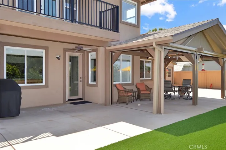 Welcome to the Backyard! Here You'll Love the Covered Patio Retreat which has Remote-Controlled Floor-to-Ceiling Privacy Shades (You Can See out, but Others Can't See in) with a TV, Heater, and Lights Included; TWO Buildings for Hobbies/Crafts/Projects; Abundant Concrete Patio Space; High-End Artificial Lawn; and Delicious Navel Oranges with Mature Oaks and Other Trees Lining the Property Below.