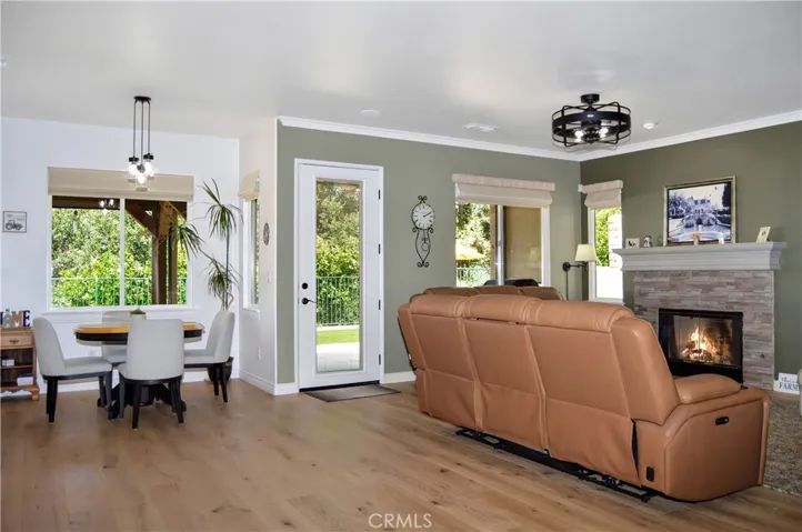 The Family Room with Cozy Fireplace is Open to the Kitchen and Nook and Shares those Tree-Filled Views. The Glass Door has Integrated Blinds and a Phantom Screen Allows the Cool Breezes in when Desired. (Fire is simulated)