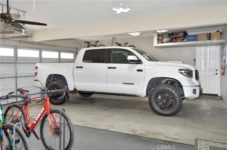 The Spacious 3-Car Garage Offers Newer Premium Shaft Drive LiftMaster Garage Door Openers, a Ceiling Fan, Overhead Storage and a Door to the Backyard Close to the Bonus Workshop