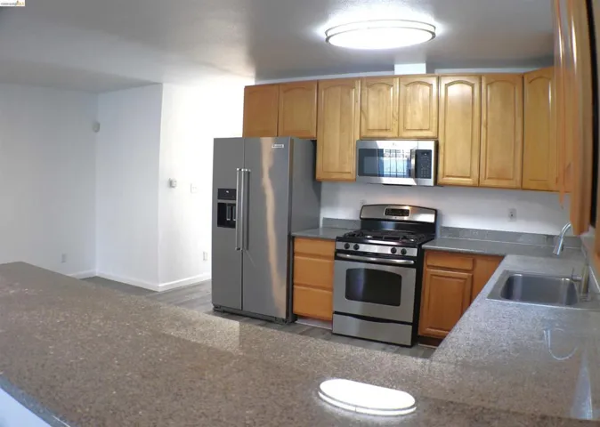 Kitchen featuring light wood cabinetry and stone-finish countertops