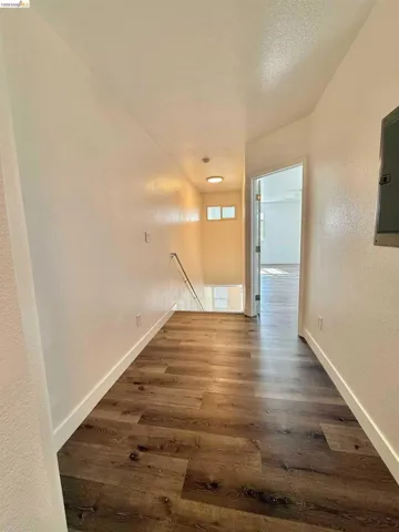 Hallway featuring wood-finish flooring, white baseboards, recessed lighting, and a neutral color palette