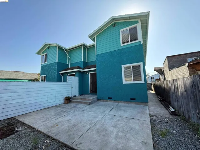 Two-story residence featuring a teal stucco and siding exterior