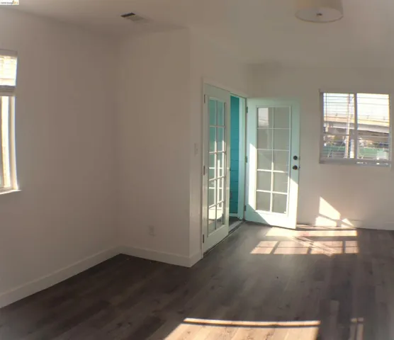 Interior room featuring wood-finish flooring, white walls, and a white ceiling with a flush-mount light fixture