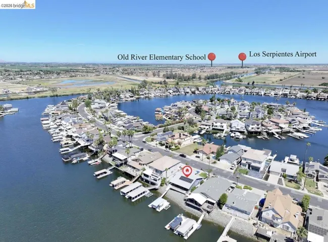 Waterfront property featuring a private boat dock, adjacent street parking, and solar panels