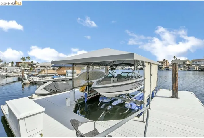 Private boat dock featuring a covered boat lift, composite decking, and water access