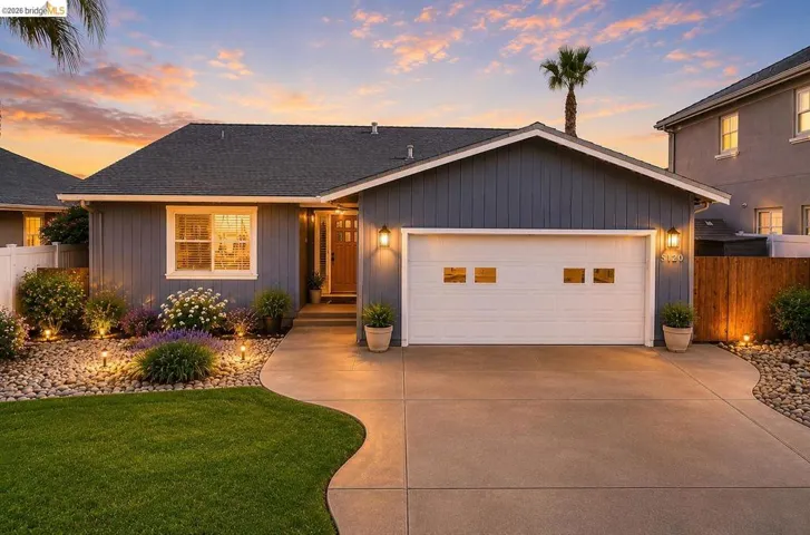 Gray siding residence featuring a white paneled garage door with window inserts