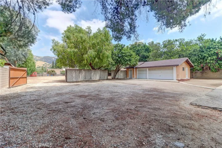 3 car garage with storage room, parking and gate to back lot.