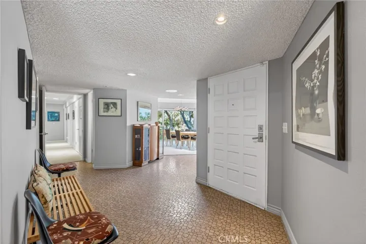 Entrance and hallway leading to other primary suite and 2 other bedrooms, powder room, and other full bathroom