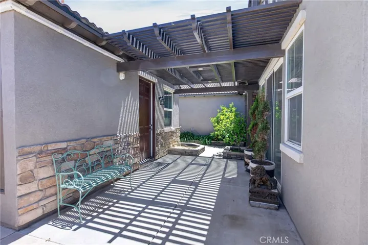 shaded front patio between home and separate bedroom with bathroom